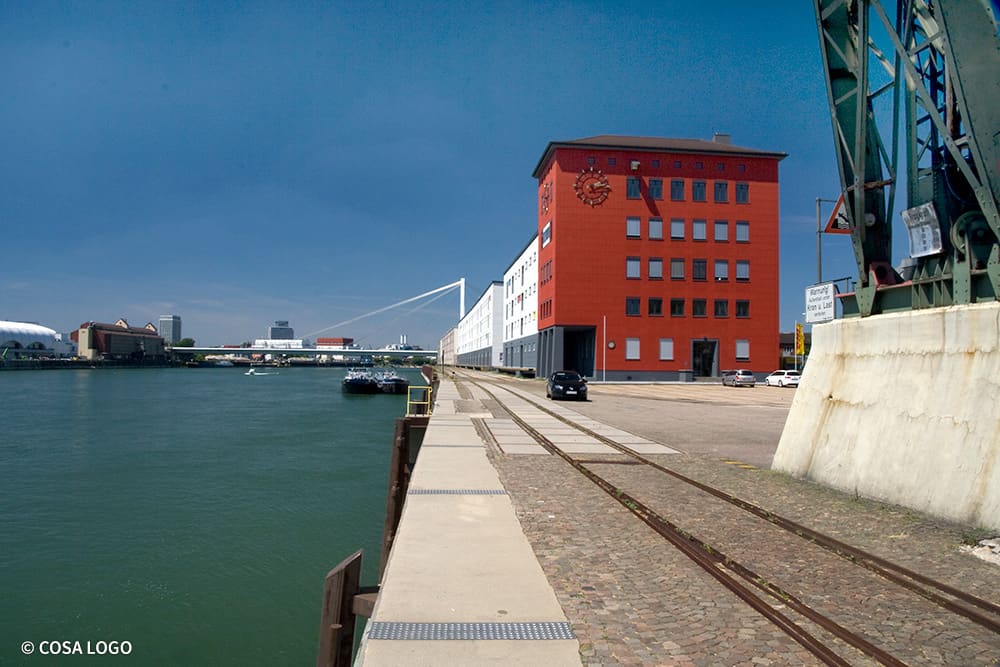 Rotes Gebäude in der Rheinkaistraße am Rheinufer.