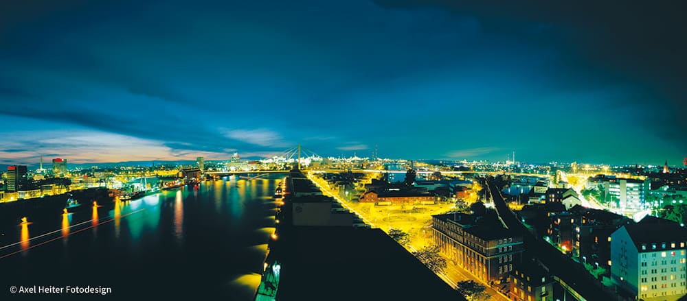 Impression von oben am Rheinufer von der Rheinkaistraße bei Nachtbeleuchtung.