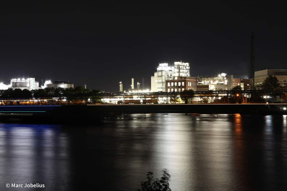 Blick auf die BASF vom Wasser aus bei Nachtbeleuchtung.